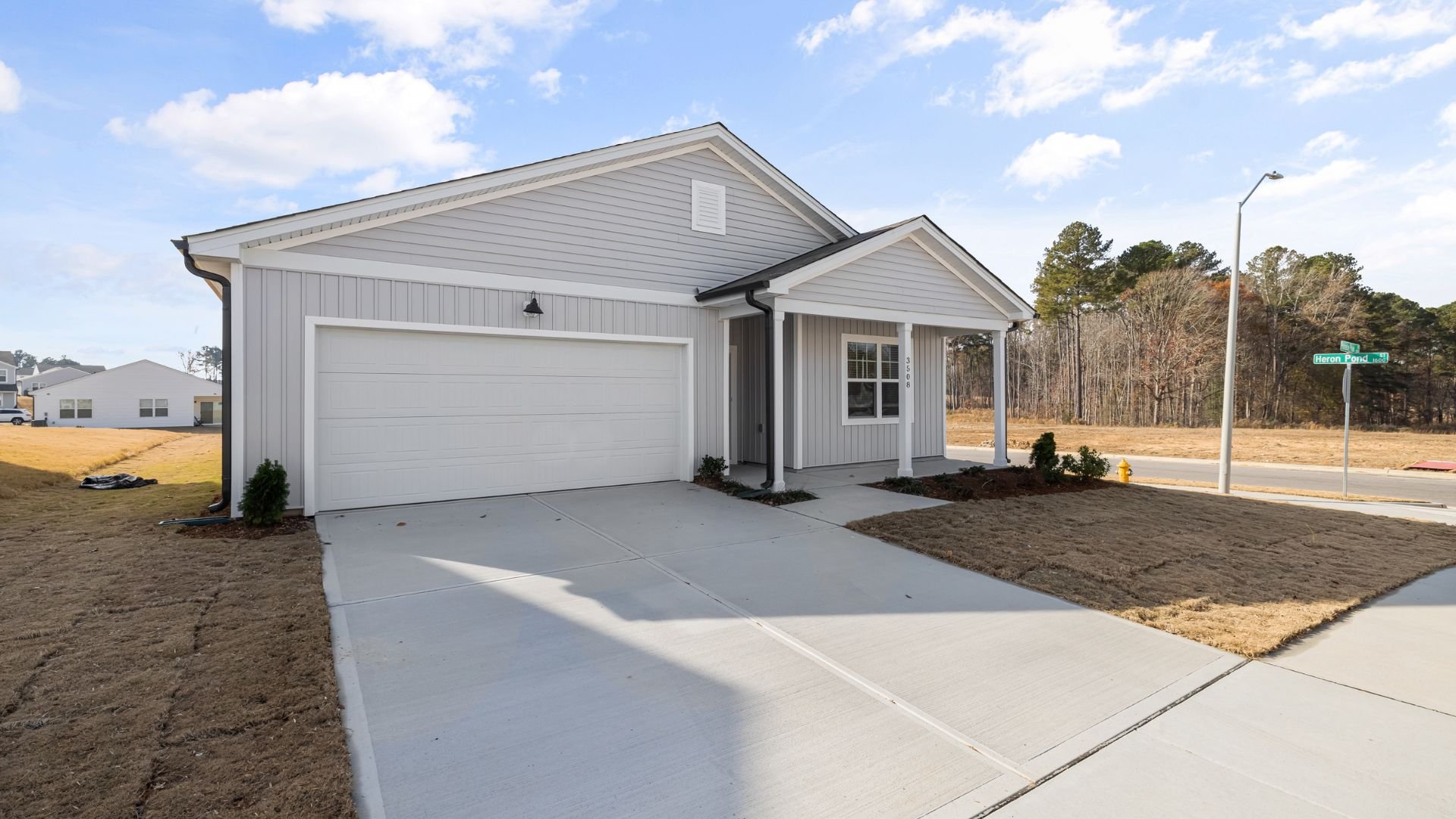 New gray suburban house with two-car garage on sunny day