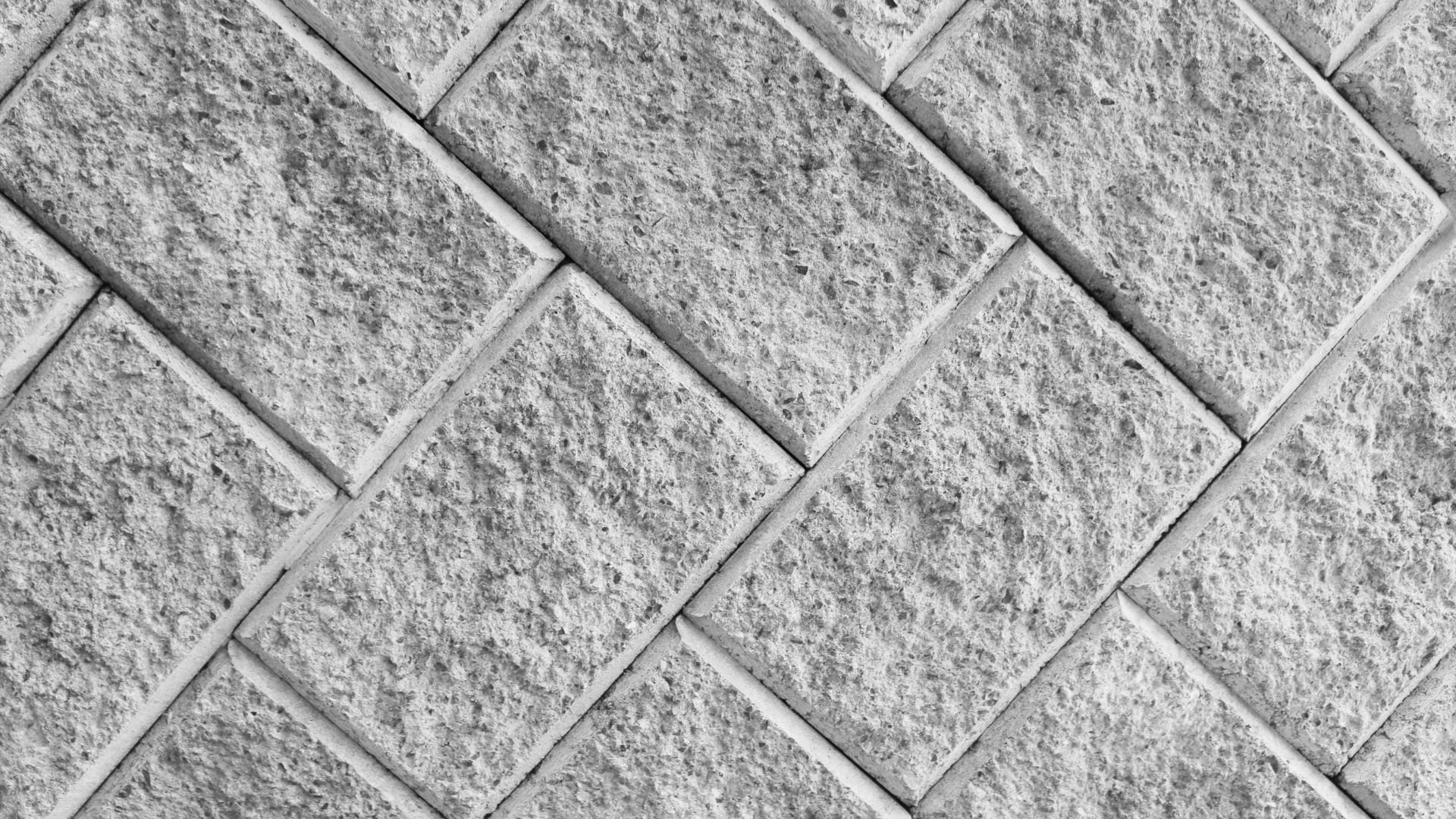 Textured gray stone tiles arranged in a diagonal herringbone pattern